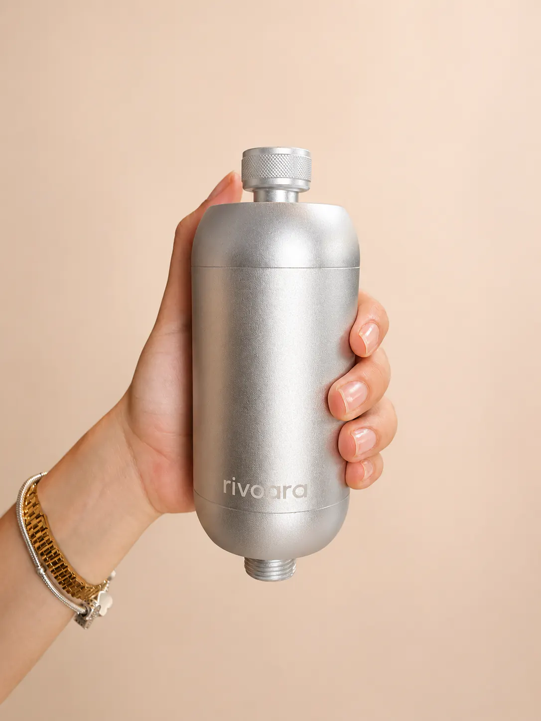 Rivoara® Duschfilter in Silber, in einer Hand gehalten